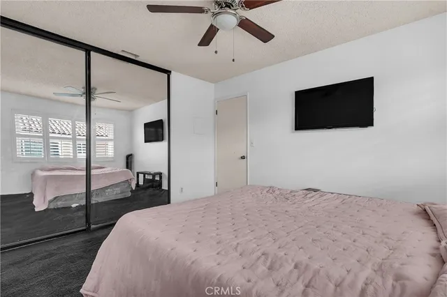 a bedroom with a bed window and a flat screen tv
