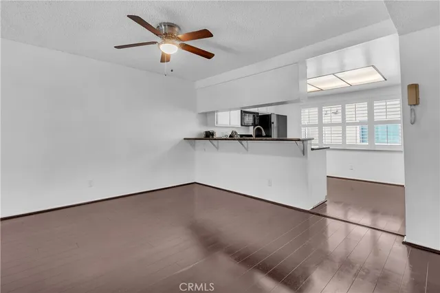 a view of a kitchen with wooden floor and a ceiling fan