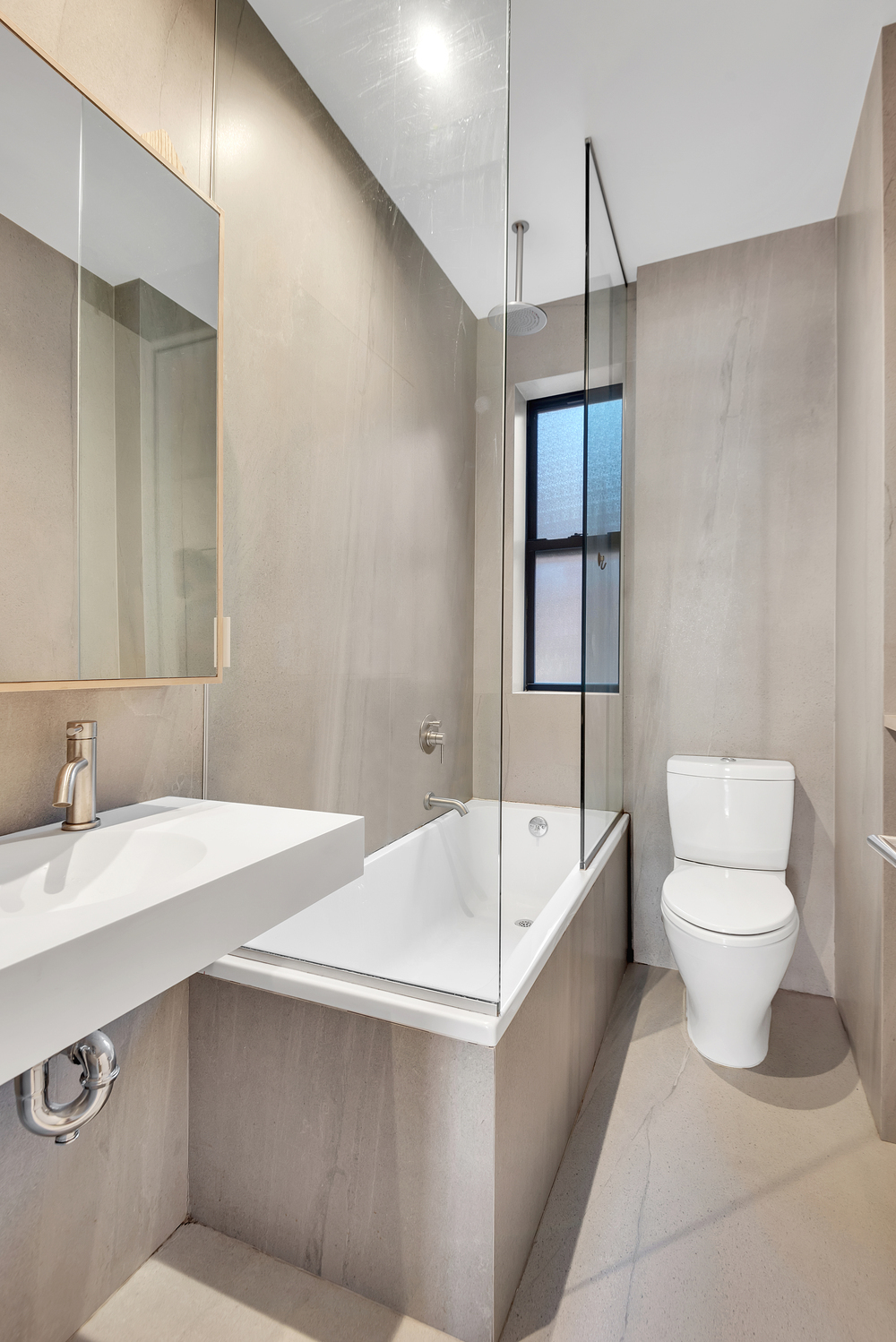 130 West 16th Street, Unit 51 Manhattan, NY 10011 - Photo 6 of 6 a spacious bathroom with a sink a toilet and shower