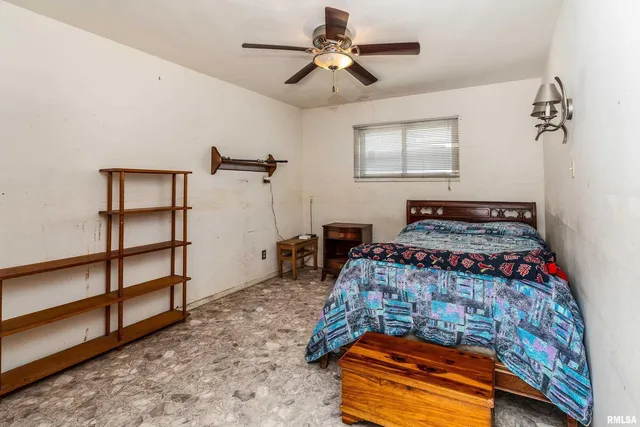 an empty room with a ceiling fan and a window
