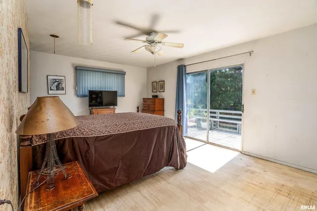 a spacious bedroom with a bed a dresser and a book shelf