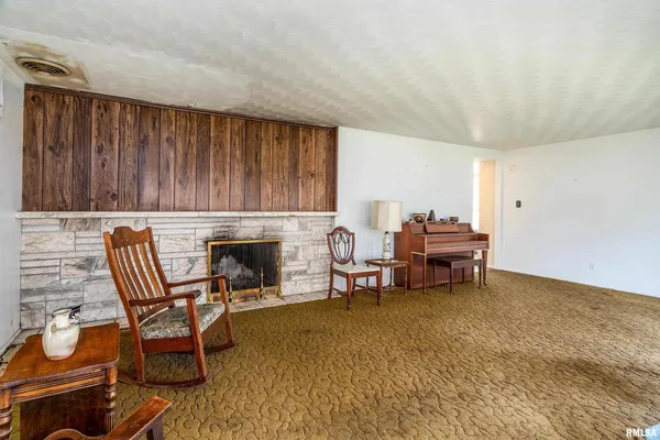 a living room with furniture a fireplace and next to a window