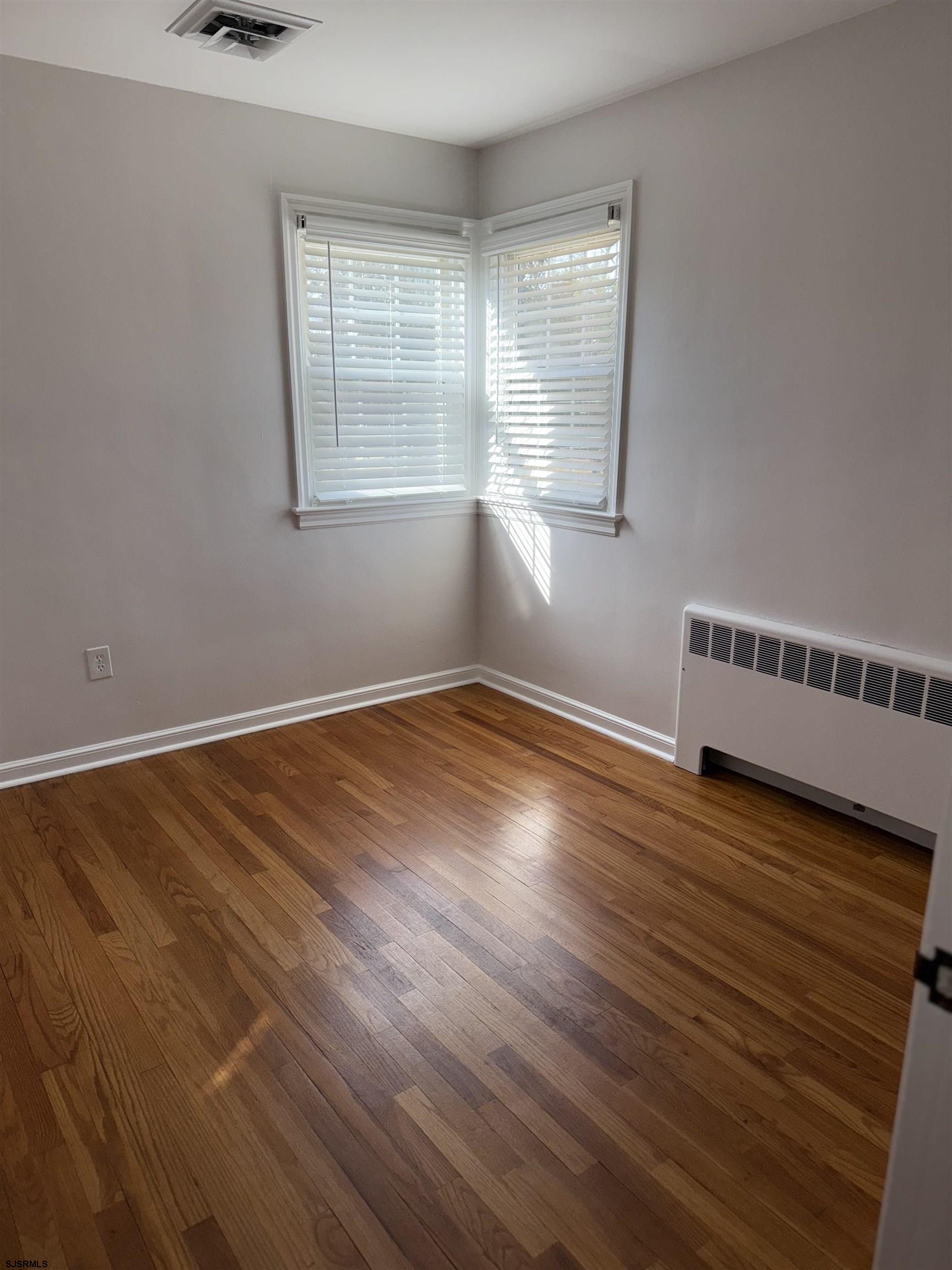 661 Grape Street Hammonton, NJ 08037 - Photo 12 of 14 a view of an empty room with wooden floor and a window