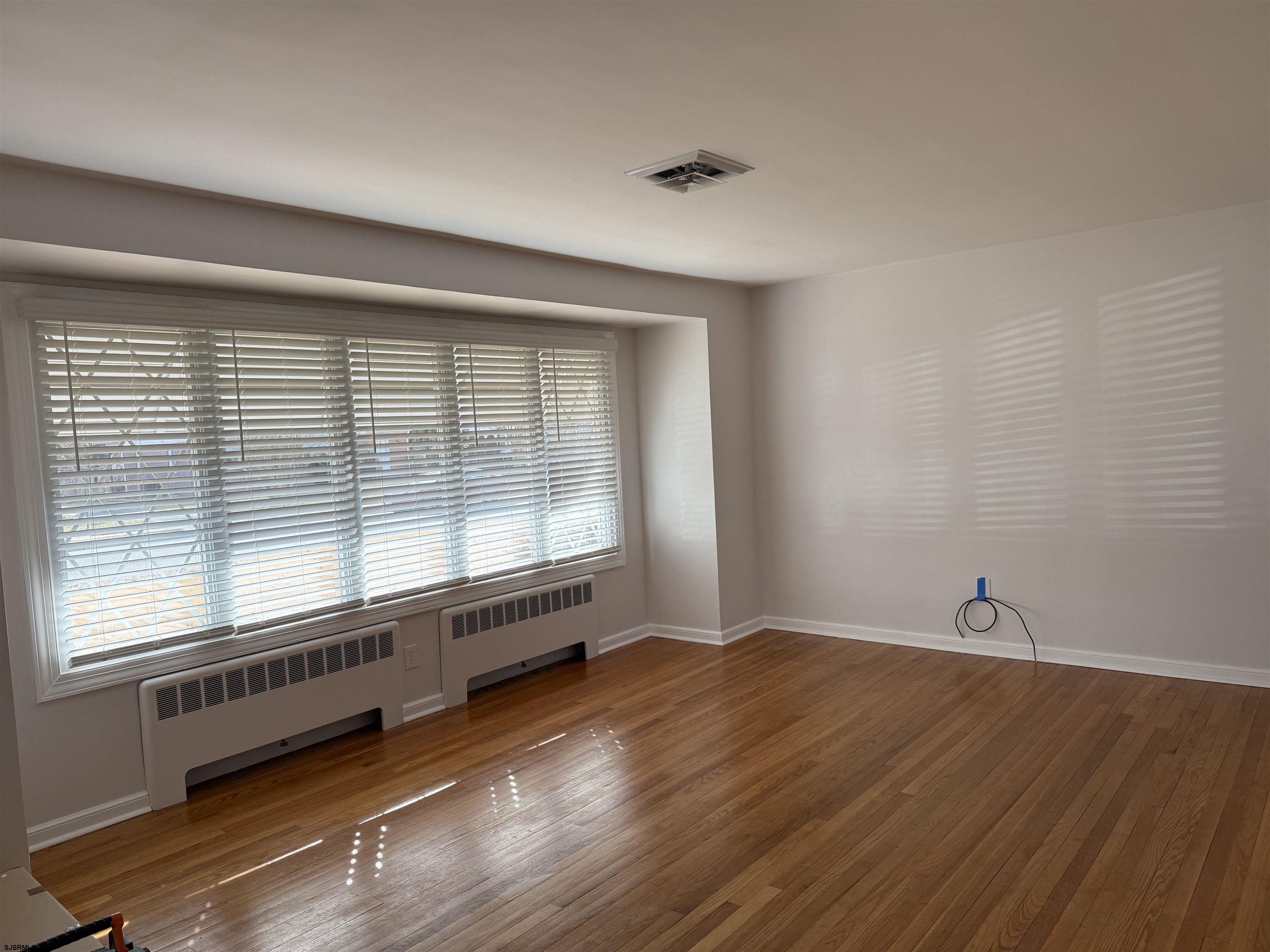 661 Grape Street Hammonton, NJ 08037 - Photo 3 of 14 a view of an empty room with wooden floor and a window