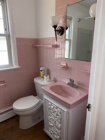 a bathroom with a toilet sink and mirror