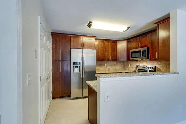a kitchen with granite countertop stainless steel appliances cabinets a sink and a counter space
