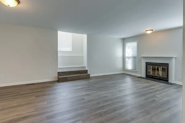 a view of an empty room with window and fire place