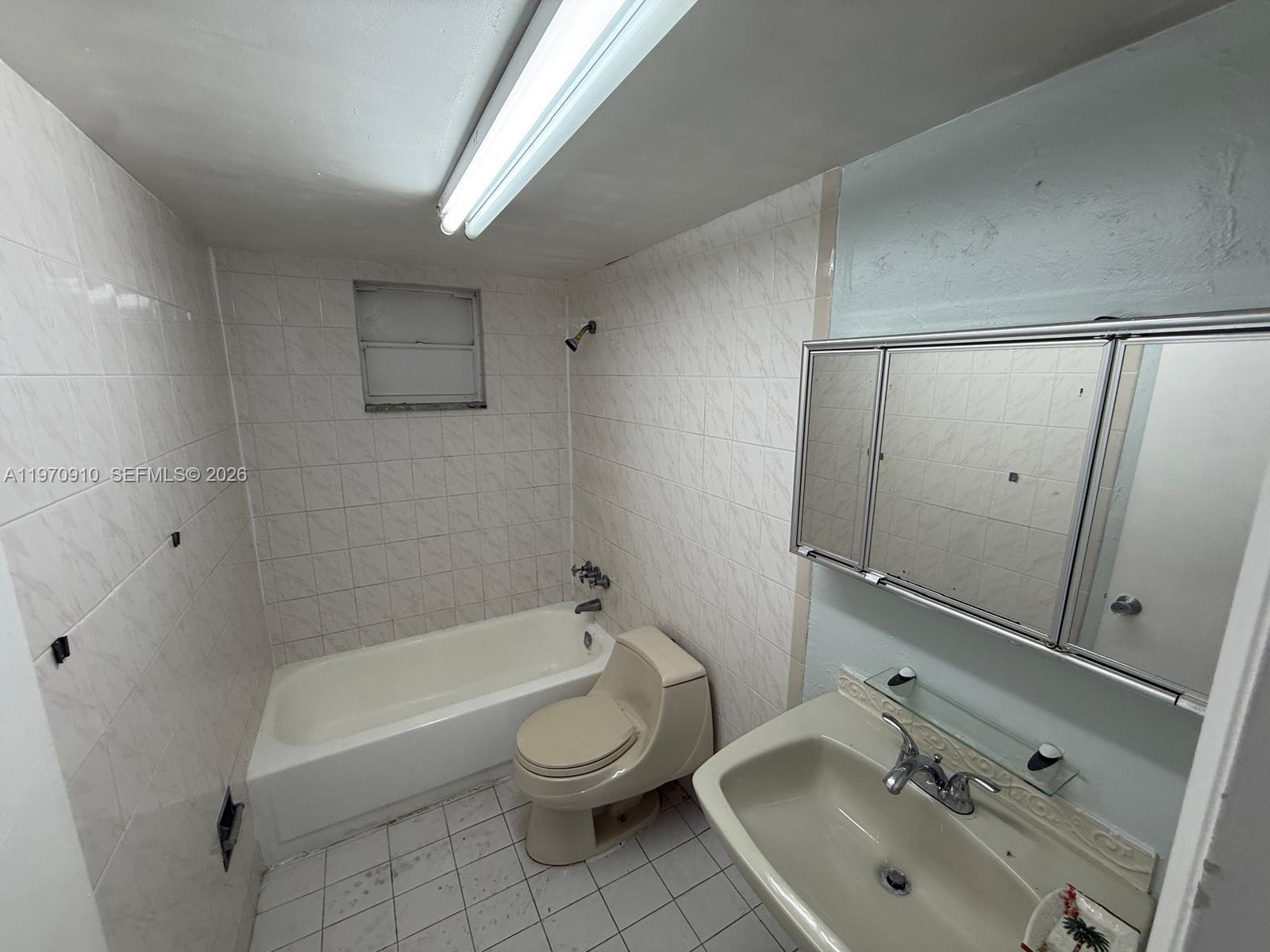 1051 Southwest 1st Street, Unit 207 Miami, FL 33130 - Photo 2 of 6 a bathroom with a sink a toilet and shower