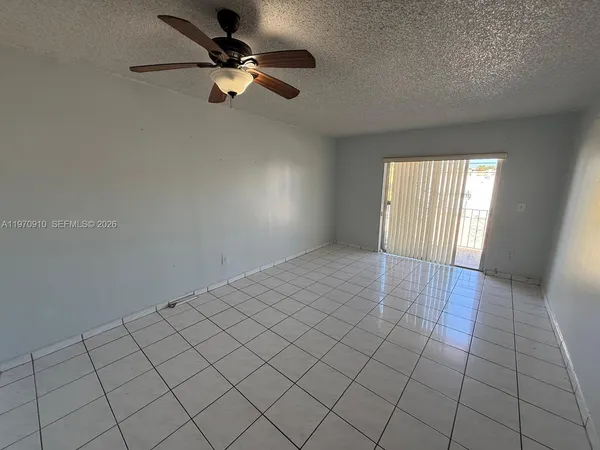 an empty room with windows and fan