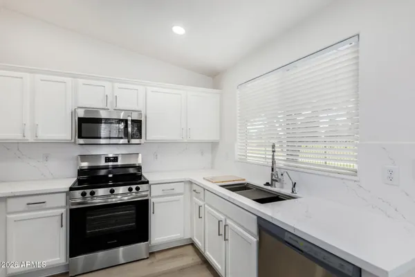 a kitchen with stainless steel appliances a sink stove and microwave