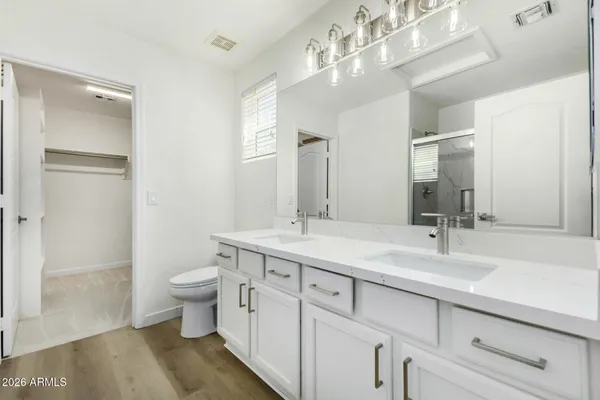 a bathroom with a double vanity sink mirror and toilet