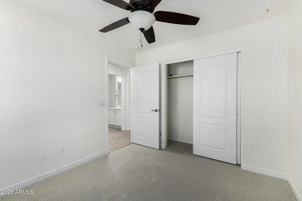 an empty room with a ceiling fan and a window