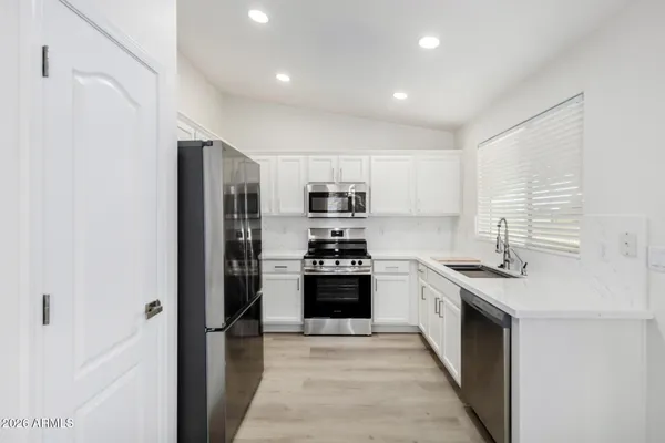 a kitchen with stainless steel appliances granite countertop a stove and a refrigerator