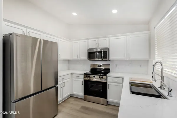 a kitchen with stainless steel appliances a refrigerator stove and sink