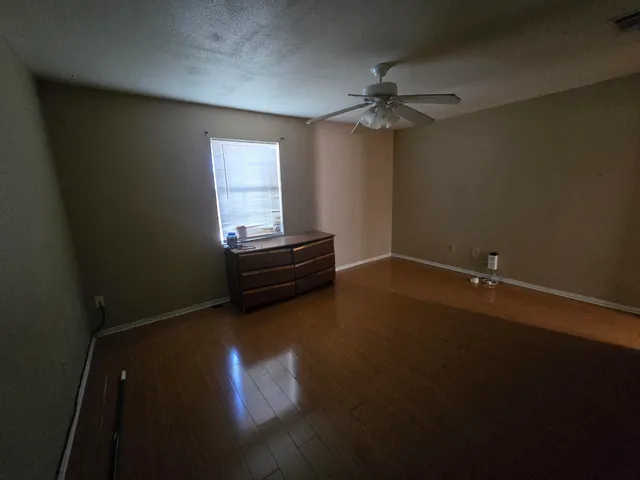 a view of room with hardwood floor and ceiling fan