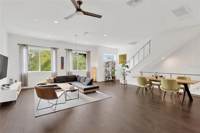 a living room with furniture a ceiling fan and a window