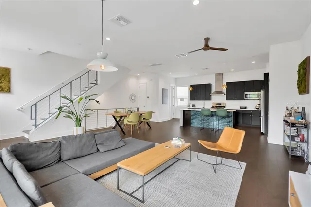 a living room with furniture kitchen view and a chandelier