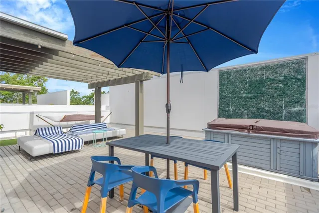 a patio with a table and chairs under an umbrella