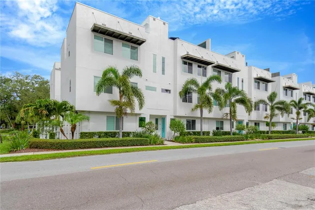 a front view of multiple houses with yard