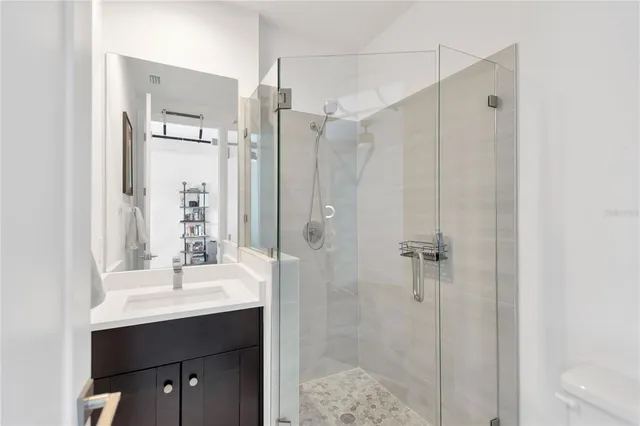 a bathroom with a shower sink and mirror