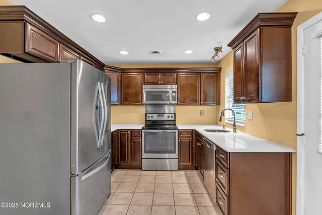 a kitchen with stainless steel appliances granite countertop a sink stove and refrigerator
