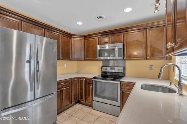 a kitchen with stainless steel appliances granite countertop a refrigerator sink and stove