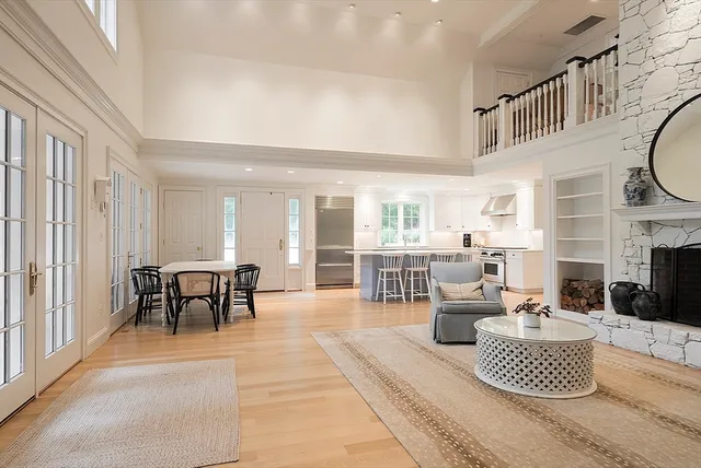a living room with furniture a fireplace and a dining table with wooden floor