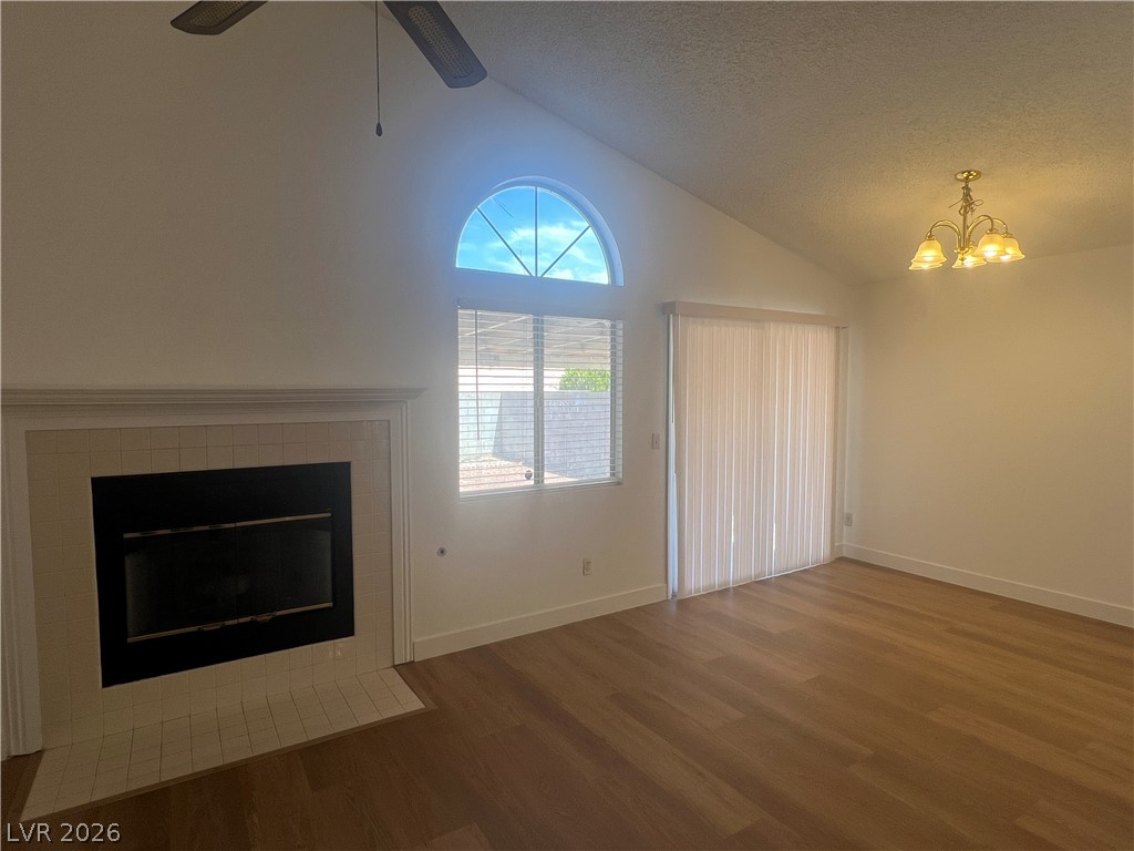 1309 Goldenglow Road Las Vegas, NV 89108 - Photo 4 of 11 A well-lit interior features a charming fireplace, vaulted ceilings, and a sliding glass door.