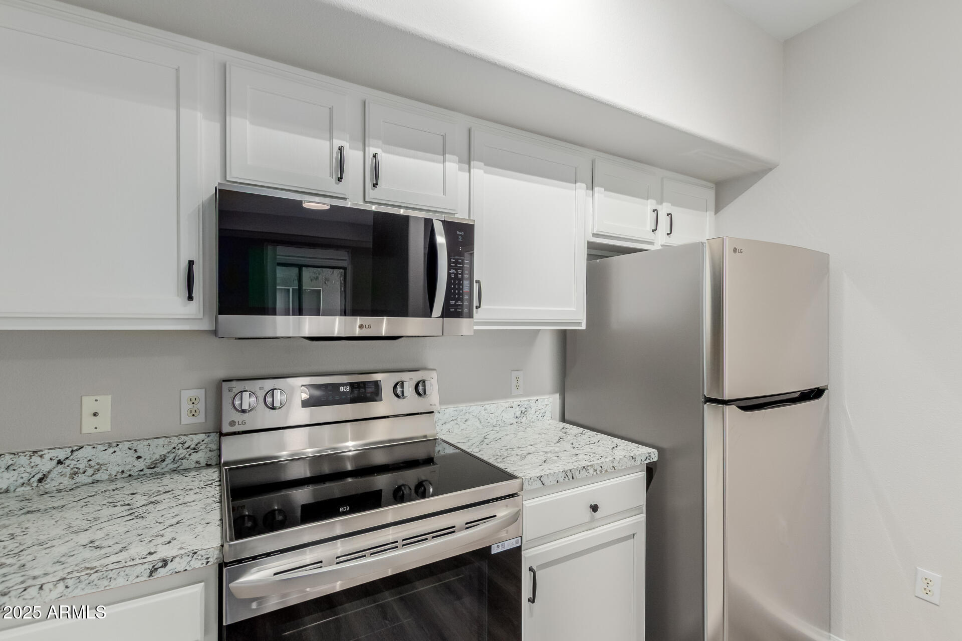 4644 North 22nd Street, Unit 1161 Phoenix, AZ 85016 - Photo 11 of 25 a kitchen with stainless steel appliances a refrigerator stove and microwave