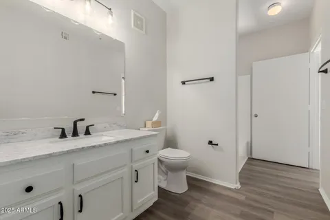 a bathroom with a granite countertop toilet sink and a mirror