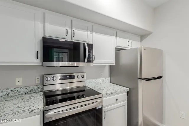 a kitchen with stainless steel appliances a refrigerator stove and microwave