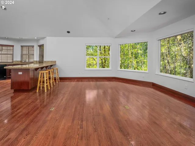 a kitchen with stainless steel appliances granite countertop wooden cabinets counter space and windows