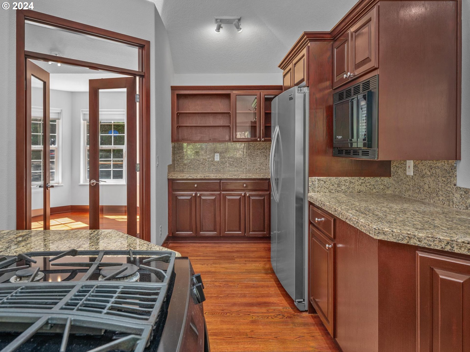 6254 Southwest Burlingame Avenue, Unit A Portland, OR 97239 - Photo 14 of 44 a kitchen with kitchen island granite countertop a stove and a sink
