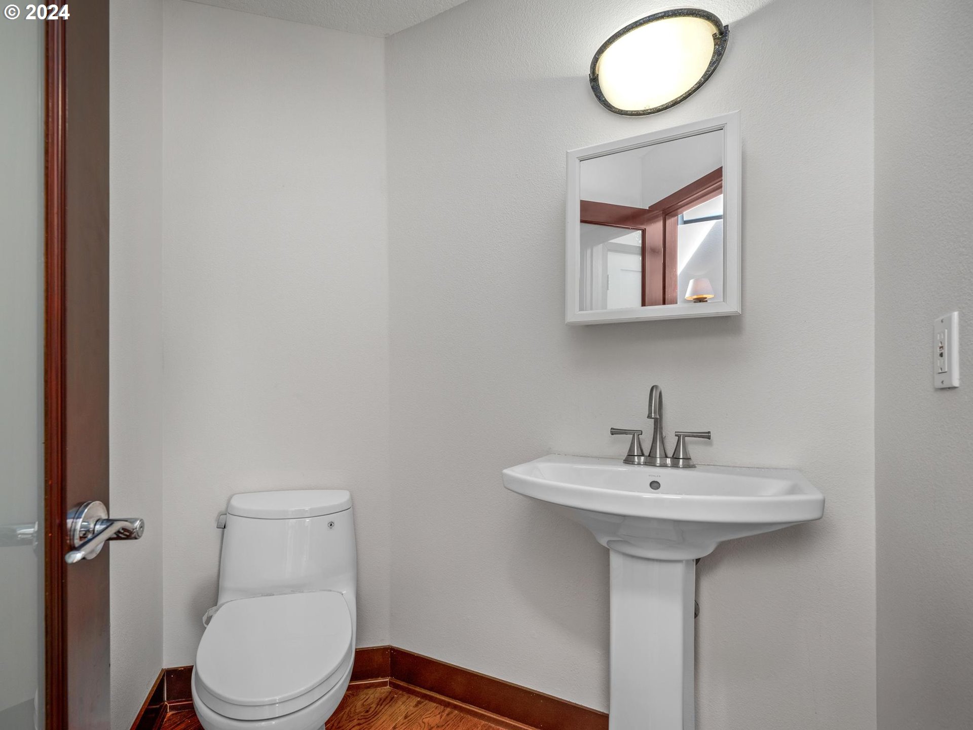 6254 Southwest Burlingame Avenue, Unit A Portland, OR 97239 - Photo 35 of 44 a bathroom with a sink toilet and a mirror
