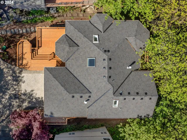 an aerial view of a house with a garden and lake view