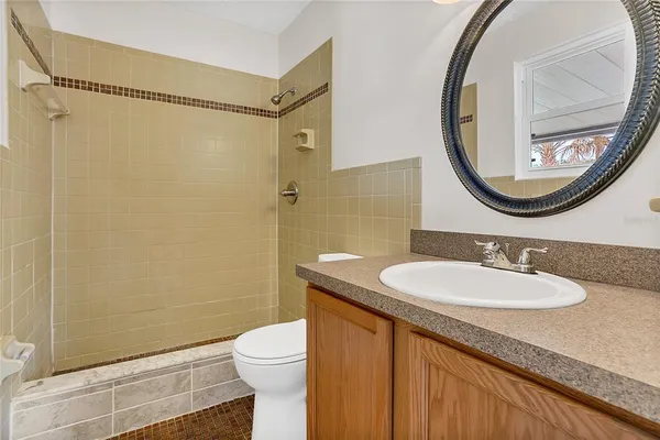 a bathroom with a granite countertop sink mirror vanity and toilet
