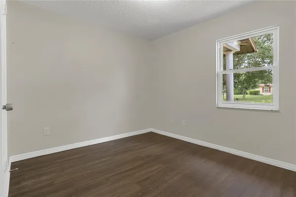 a view of a room that has wooden floor and window