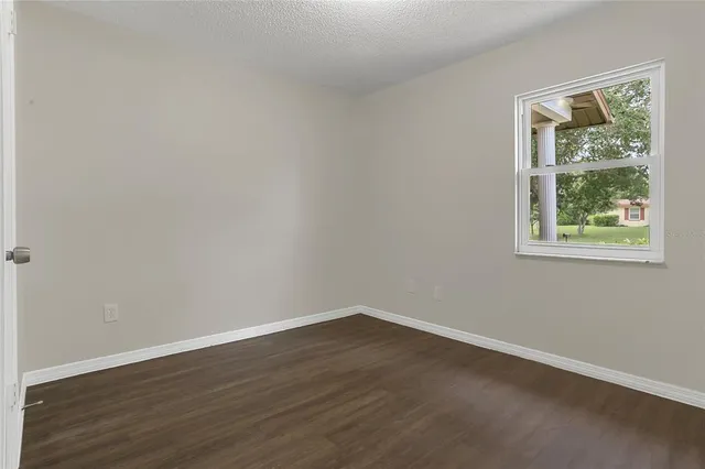 a view of a room that has wooden floor and window