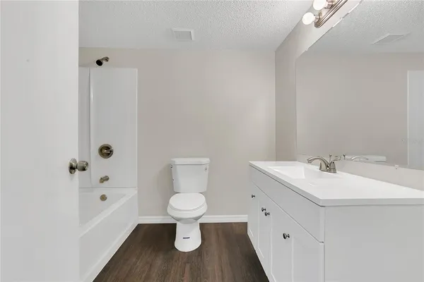 a bathroom with a white sink a toilet a mirror and shower