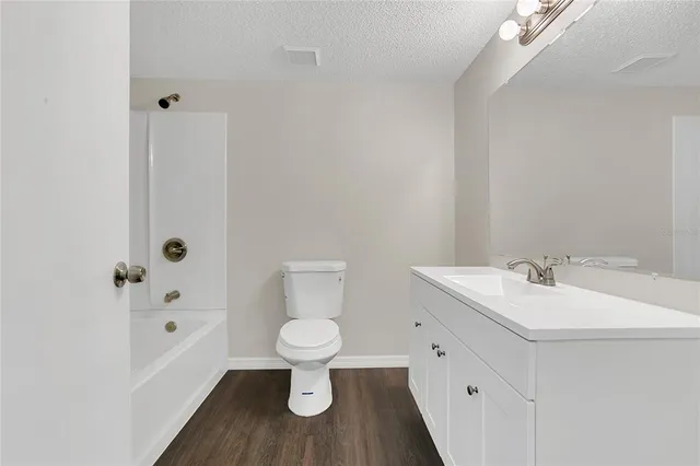 a bathroom with a white sink a toilet a mirror and shower