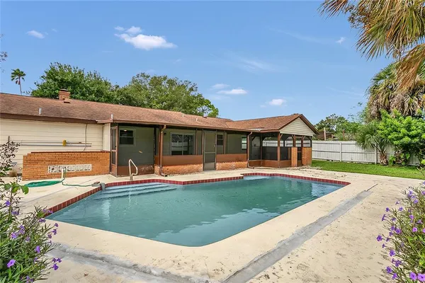a view of house with swimming pool outdoor seating