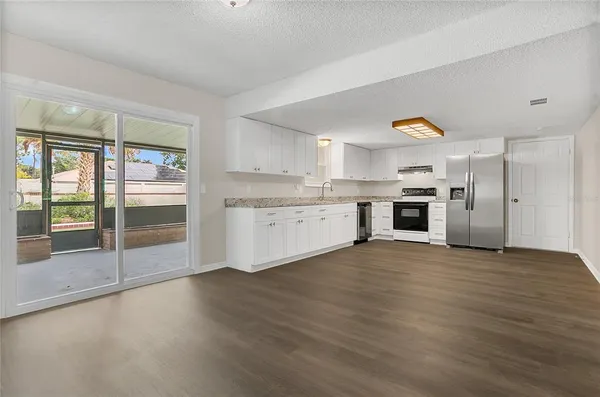 a view of a kitchen with a stove wooden cabinets and a fireplace