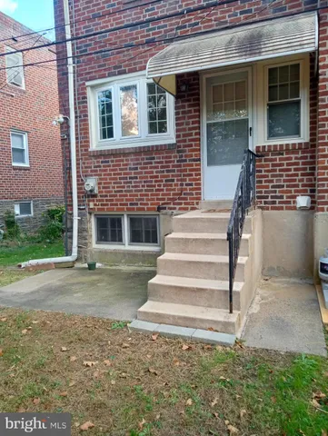a backyard of a house with a yard and large tree