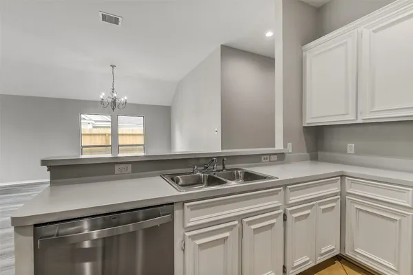 a view of a kitchen sink window and cabinets