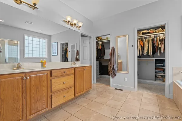 a spacious bathroom with a granite countertop sink mirror and cabinets