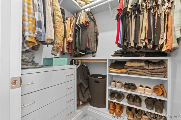 a view of walk in closet with clothes and shoes