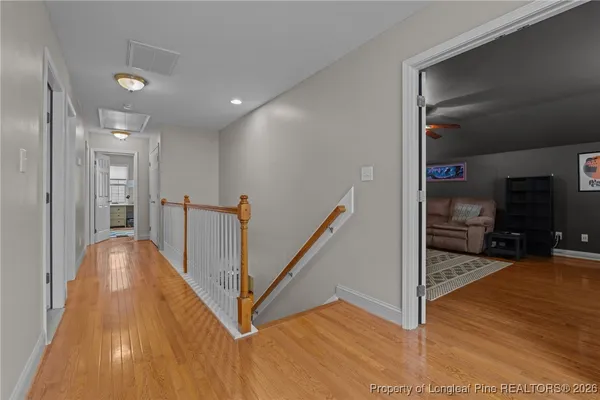 a view of a hallway with wooden floor and stairs