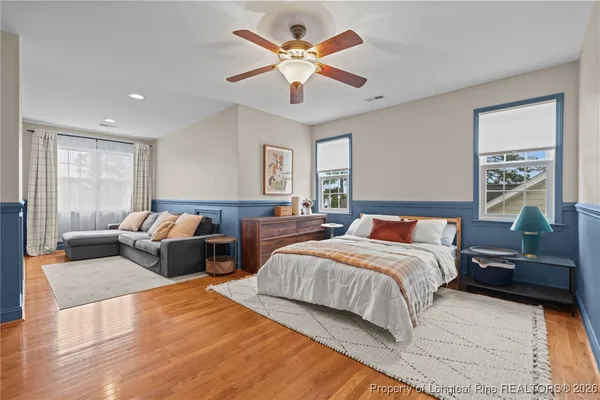 a spacious bedroom with a large bed couch and windows