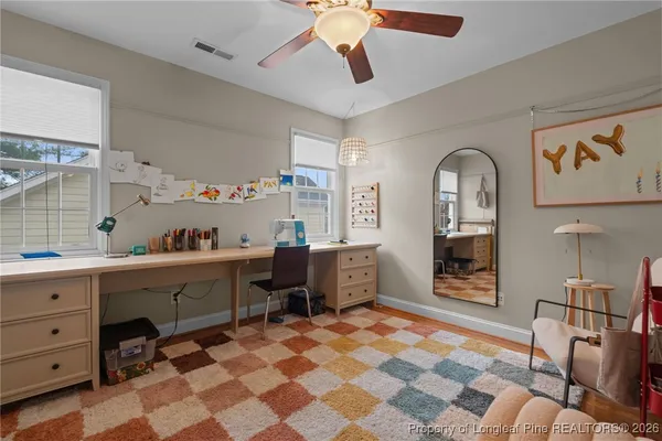 a view of a workspace with furniture and a window