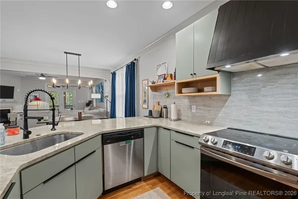 a kitchen with stainless steel appliances granite countertop a sink and a stove
